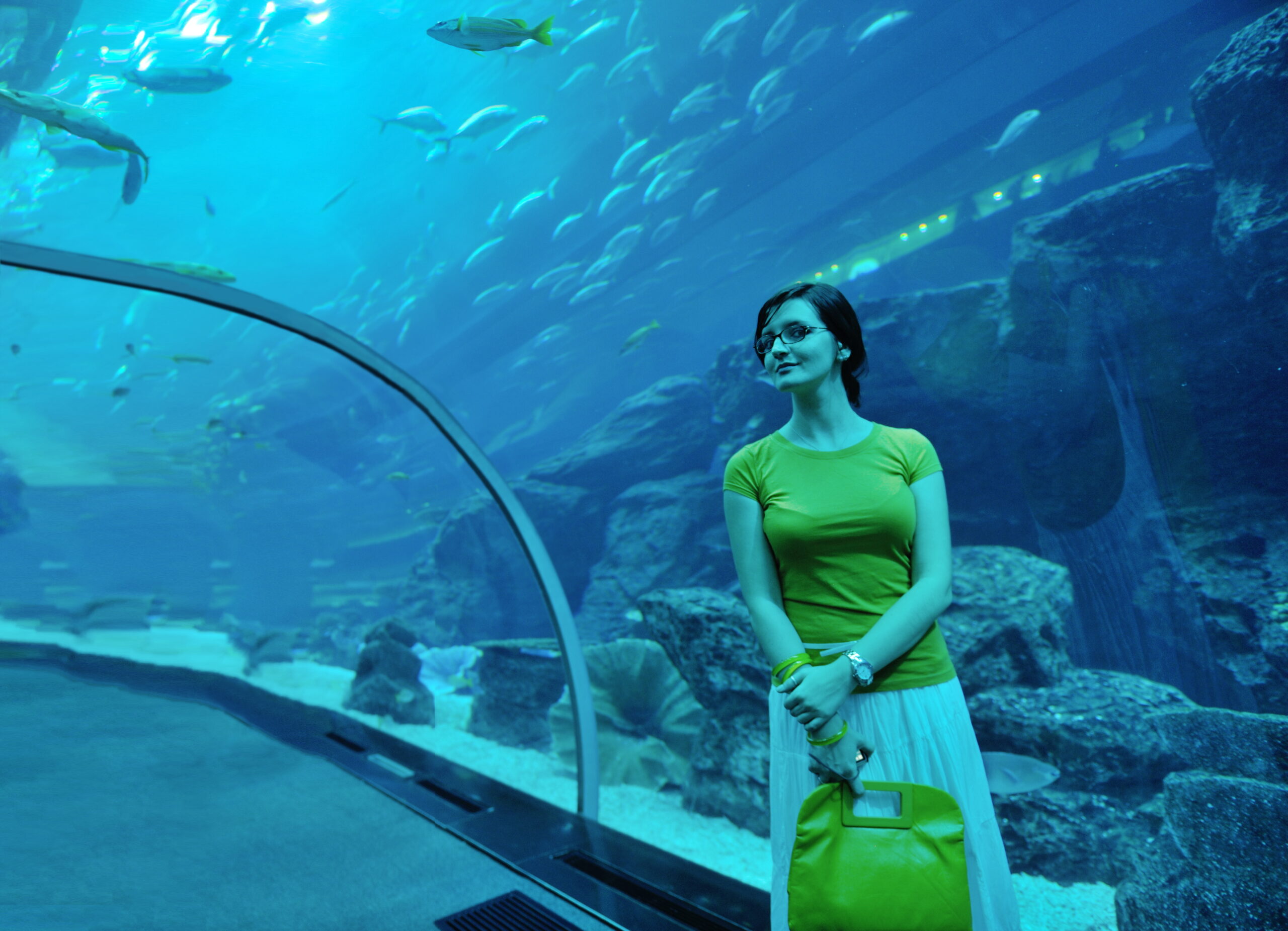 young woman with big aquarium in backgrond